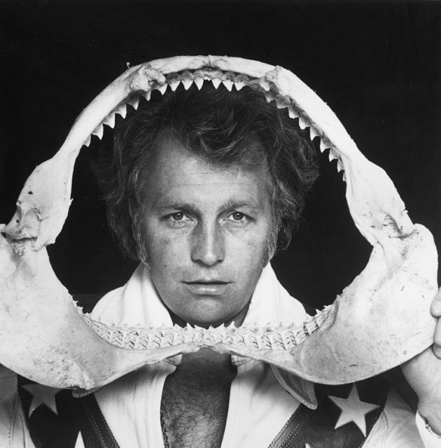 January 1977: American stunt artist Evel Knievel holds and looks through a shark's jaw