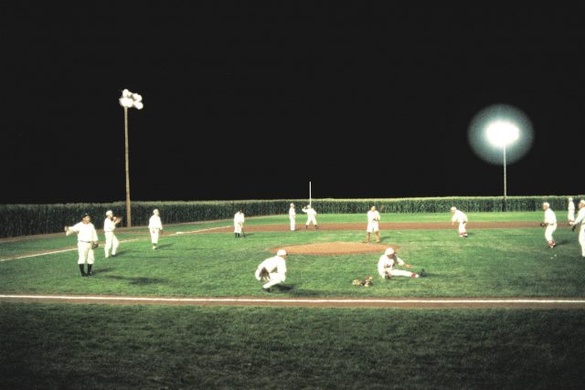 Baseball players on the Field of Dreams at night