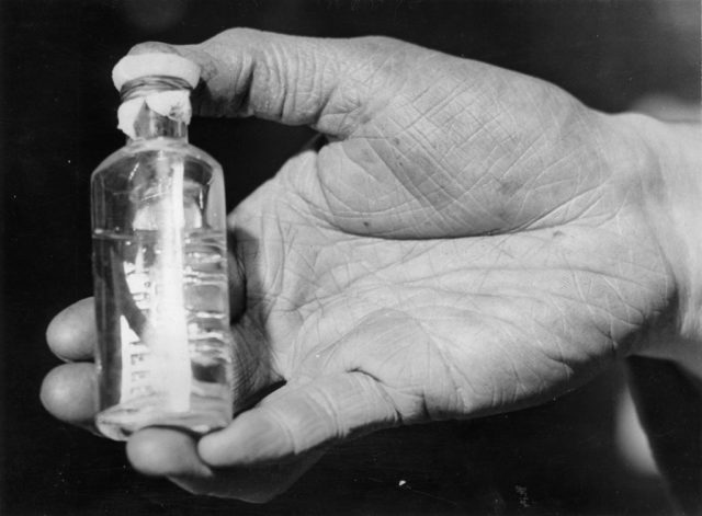 a hand holds a bottle of leeches