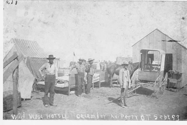 Men standing in front of Wild West Hotel on Calamity Avenue in Perry, Oklahoma Territory. (Photo Credit: © CORBIS/Corbis via Getty Images)