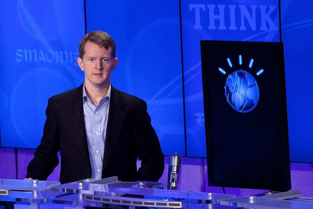 Ken Jennings standing next to a computer