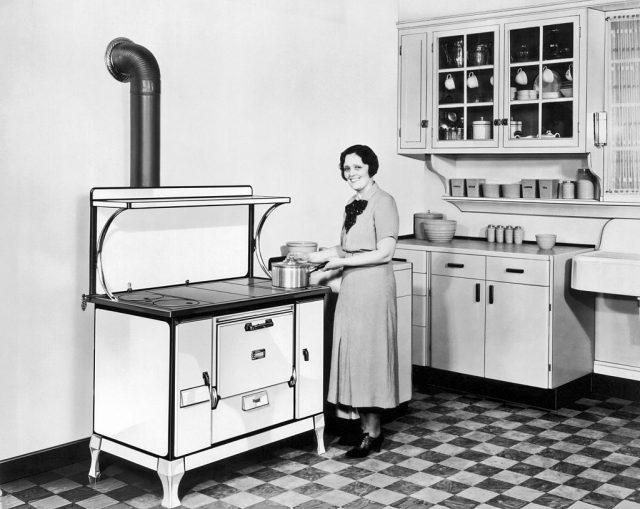 Woman standing beside a kitchen stove