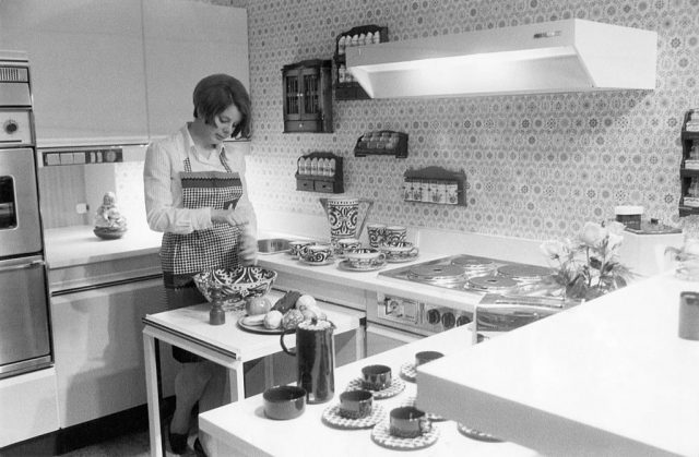 Woman standing over a bowl in a kitchen