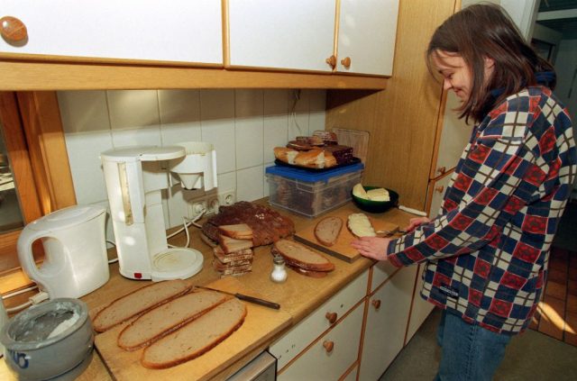 Woman buttering bread at a kitchen counter