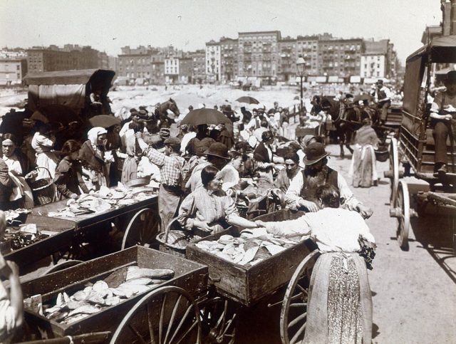 Women standing around carriages filled with fish