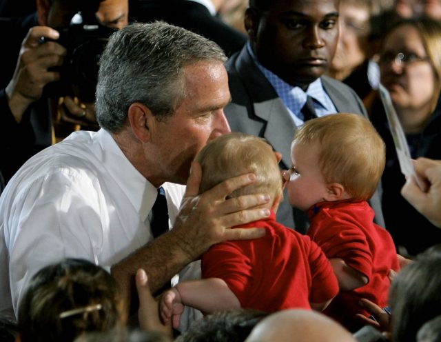 President Bush kisses two babies 