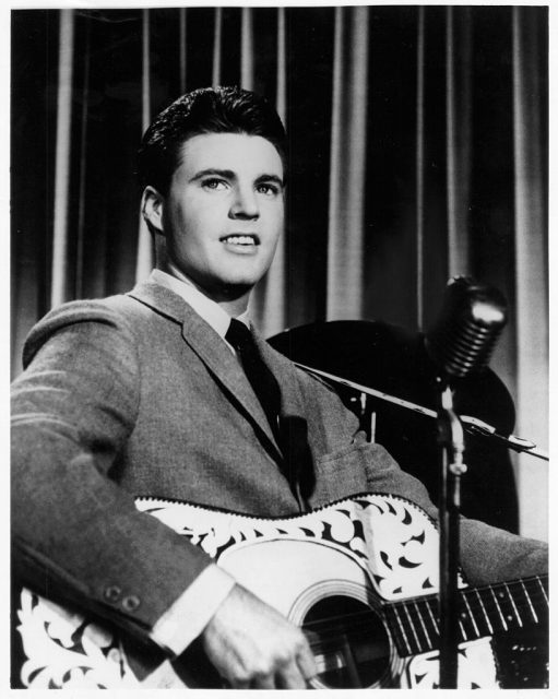 Pop singer Rick Nelson performs onstage holding an acoustic guitar in circa 1957. (Photo Credit: Michael Ochs Archives/Getty Images)