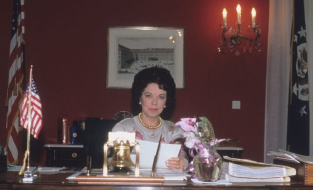 Shirley Temple sitting at a desk
