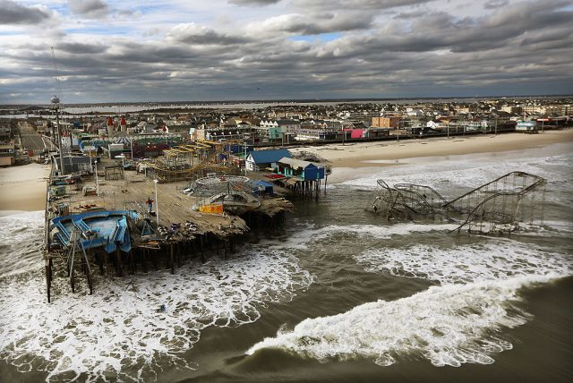 Damaged boardwalk with amusement park rides in the surf