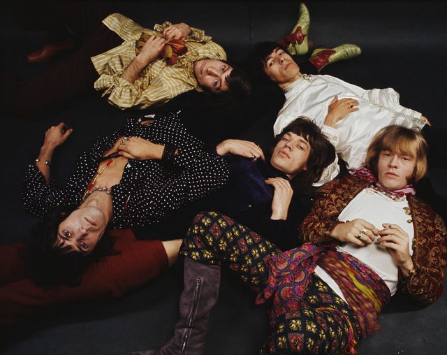 Members of the Rolling Stones lying on the ground