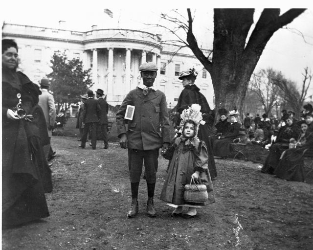 A young boy and girl holding hands in front of the White House