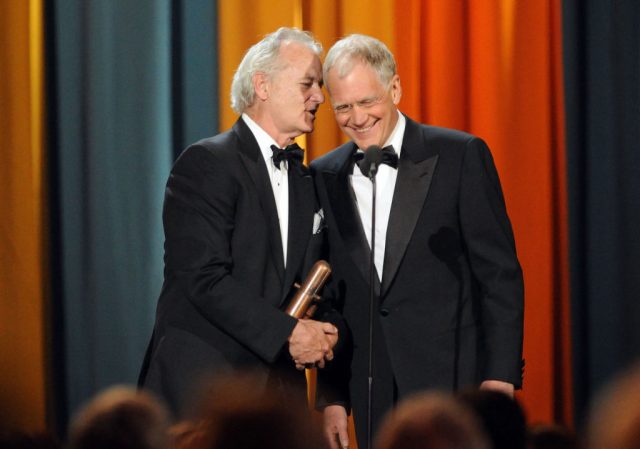 Bill Murray speaking into David Letterman's ear