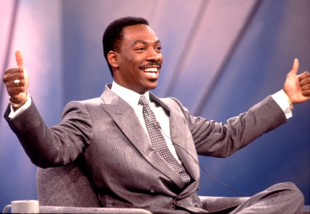 Eddie Murphy sitting down with his arms spread