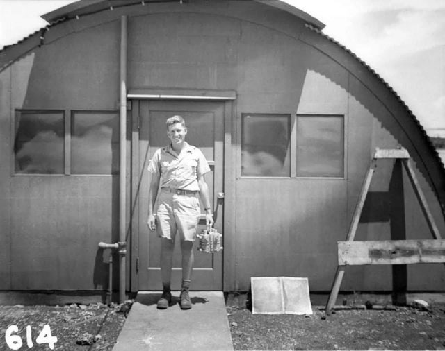 Physicist Harold Agnew holding the core of an atomic bomb 