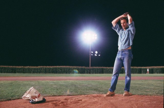 Ray Kinsella holding a baseball above his head