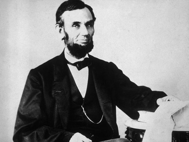 The 16th American president, Abraham Lincoln (1809 – 1865), sitting and leafing through documents, Washington, D.C. (Photo Credit: Hulton Archive/Getty Images)