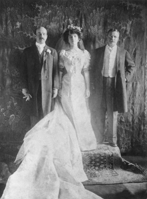 1905: Wedding portrait of Nicholas Longworth (left) and Alice Roosevelt posing with the bride’s father, U.S. President Theodore Roosevelt. The bride is wearing a white dress, white gloves, a veil, and a train. (Photo Credit: Hulton Archive/Getty Images)