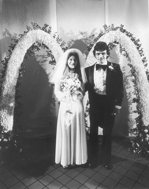 Couple in wedding attire in front of the McDonald's golden arches