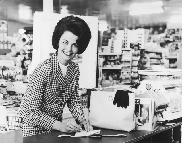 woman writing a check at the grocery store