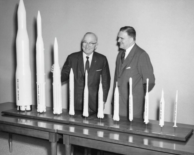 James Webb and Harry Truman standing behind model rockets