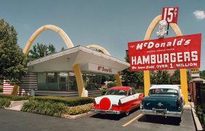 Two cars parked outside of a McDonald's Restaurant