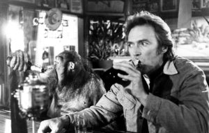 Clint Eastwood having a drink with a monkey