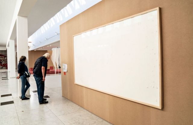 People stand in front of an empty frame hung up at the Kunsten Museum in Aalborg, Denmark, on September 28 2021. (Photo Credit: HENNING BAGGER/Ritzau Scanpix/AFP via Getty Images)