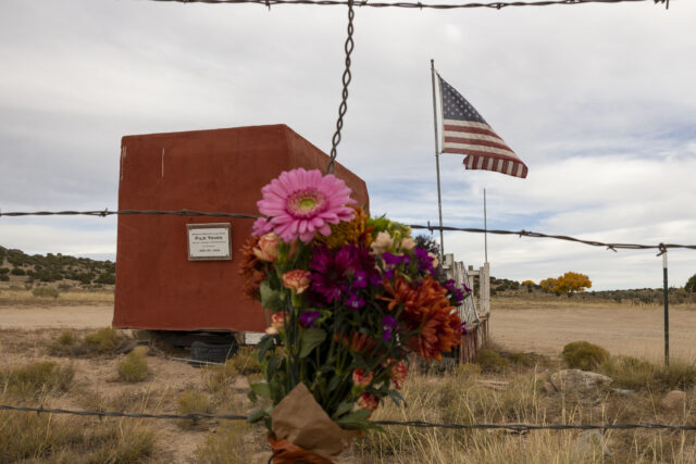 Flowers attached to a barbed wire fence