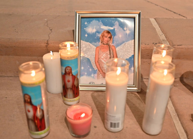 Lit candles around a framed photo of Halyna Hutchins