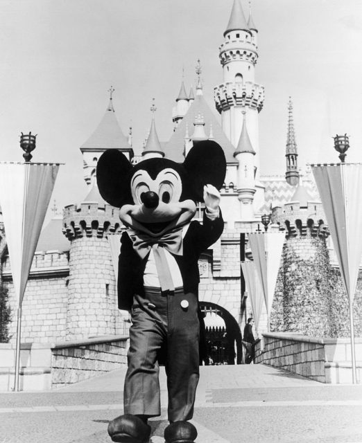 circa 1955: A person in a Mickey Mouse costume at the gate of the Magic Kingdom at the Disneyland theme park, Anaheim, California. (Photo Credit: Hulton Archive/Getty Images)