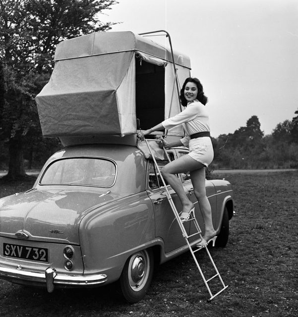 October 1956: British actress and model Marigold Russell demonstrates the ‘Roofsleeper’, a car tent mounted on a plinth shaped to suit the contours of a car roof. (Photo Credit: Harry Kerr/BIPs/Getty Images)