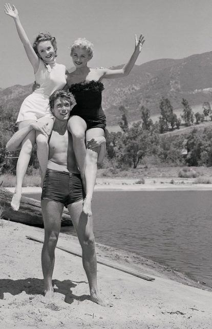 This “campus” appears to be just what the doctor ordered during the heat wave plaguing most of the U.S. these days, as three young hopefuls indulge in some open-air matriculation in Universal-International Pictures’ Stardom School. Keystone of the intense “study” group is San Francisco’s Clint Eastwood. On his right shoulder is Olive Sturges of Ocean Falls, British Columbia, and on his left is Deni Crayne who hails from Minneapolis. (Photo Credit: Bettmann / Contributor)