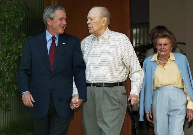 US President George W. Bush and former President Gerald Ford and his wife Betty walk out of the Ford residence after a visit call by Bush April 23, 2006 in Rancho Mirage, CA (Photo Credit: MANDEL NGAN/AFP via Getty Images)