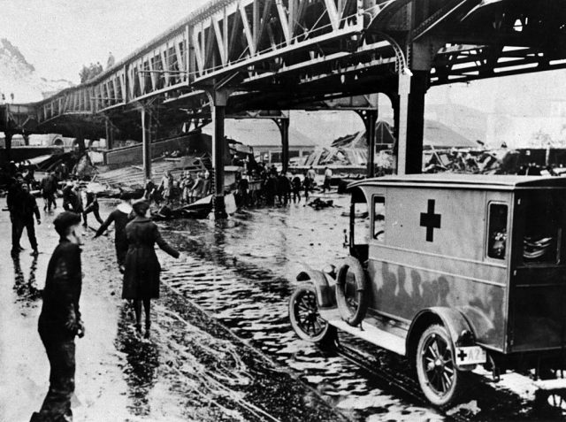 Police, firemen, Red Cross workers, civilian volunteers, and cadets from the USS Nantucket training ship berthed nearby rushed to the scene on Jan. 15, 1919, after a giant tank in the North End collapsed, sending a wave of an estimated 2.3 million gallons of molasses through the streets of Boston. They rescued many terrified people but others they were unable to reach. Twenty-one people died and 150 were injured. (Photo Credit: The Boston Globe via Getty Images)