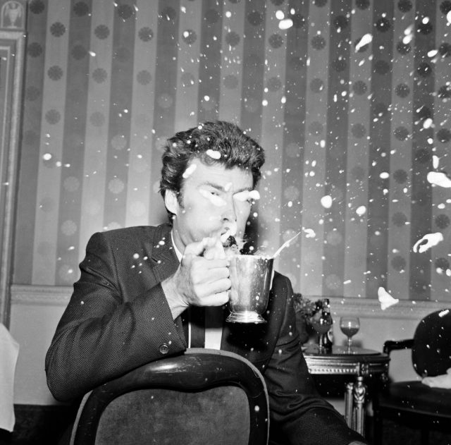 Clint Eastwood arrived in Manchester today and found his favourite pint of beer in the city. ‘I love beer but the froth gets up my nose’ he said, and immediately blew it off the top of his pint, 12th June 1967. (Photo Credit: Tom Lyons/Mirrorpix/Getty Images)