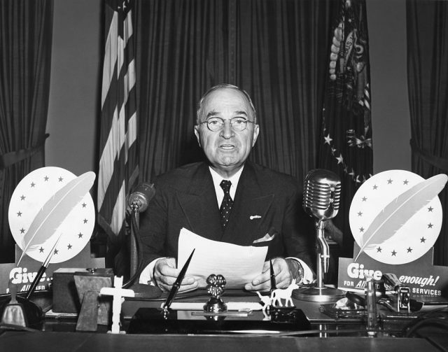 Harry Truman sitting at his desk