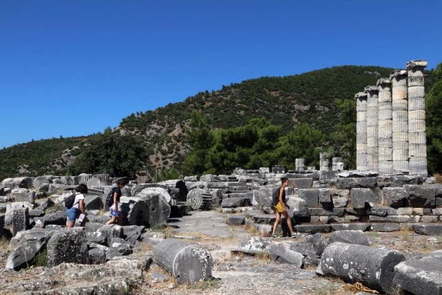 Woman walking through the remnants of an ancient Greek city