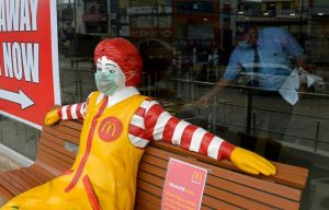 Ronald McDonald sitting on a bench