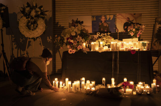 Jamie Frazer kneeling before a candlelight vigil for Halyna Hutchins