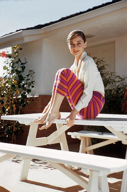Audrey Hepburn sitting on a picnic table