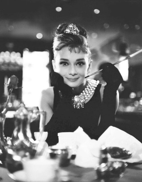 Holly Golightly resting her elbows on a table