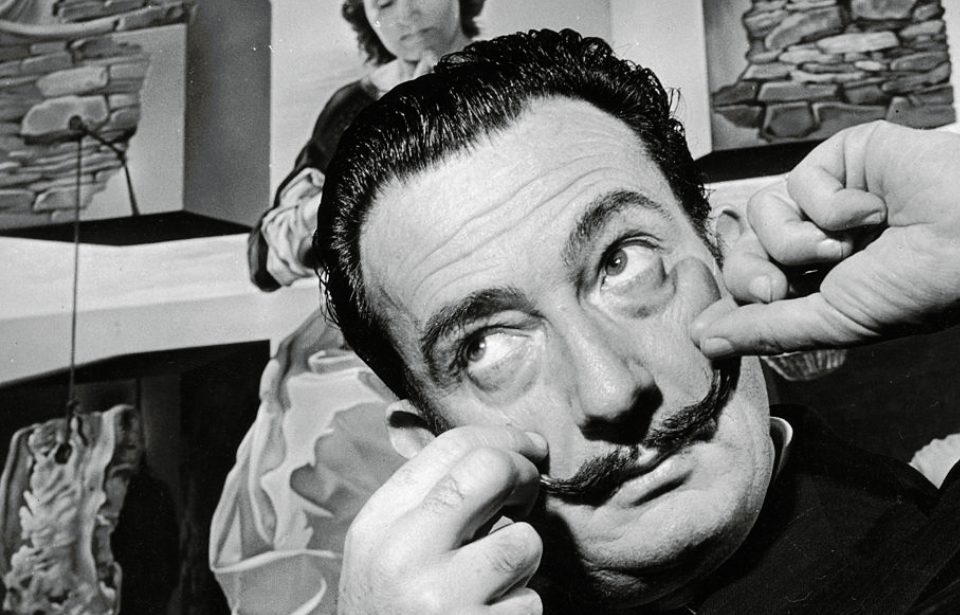 Spanish surrealist artist Salvador Dali (1904 - 1989) in London with one of his paintings entitled 'The Madonna of Port Lligat', December 1951. (Photo Credit: George Konig/Keystone Features/Getty Images)