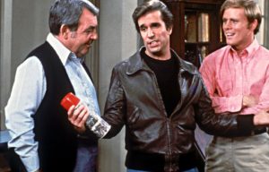 Fonzie holding a can with his arms outstretched