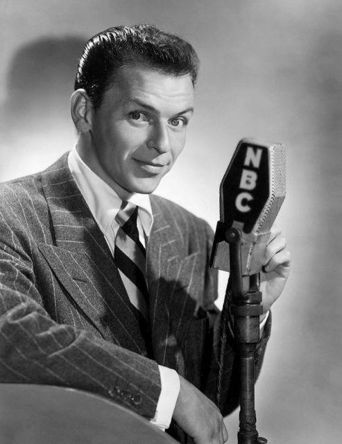 Frank Sinatra standing with a microphone
