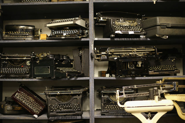 Typewriters stacked on shelves