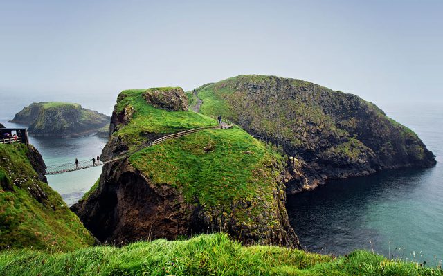 Carrick-a-Rede Rope Bridge is a rope suspension bridge near Ballintoy, County Antrim, Northern Ireland. The bridge links the mainland to the tiny Carrick Island. The bridge spans twenty meters and is thirty meters above the rocks below. (Photo Credit: Michelle McMahon / Contributor)