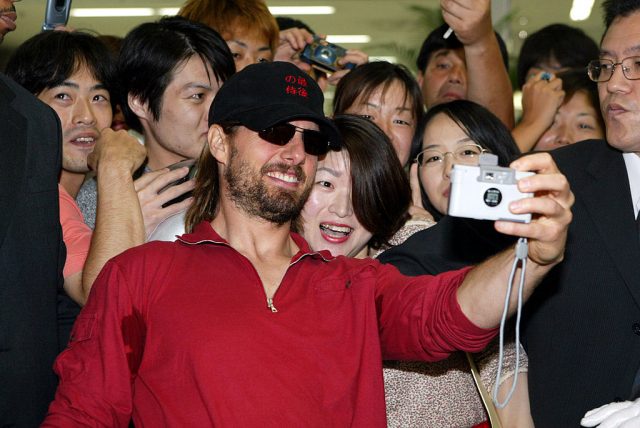 Actor Tom Cruise poses for photos with Japanese fans in the arrival lobby at Haneda Airport August 28, 2003 in Tokyo, Japan. (Photo Credit: Koichi Kamoshida/Getty Images)