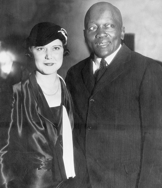 (Original Caption) 10/7/1931-Los Angeles, CA: Jack Johnson standing with his fourth wife, Irene Pineau, at the opening of his nightclub, The Showboat, in Los Angeles. The couple were married in 1925, when Johnson was 47 years old. (Photo Credit: Bettmann / Contributor)