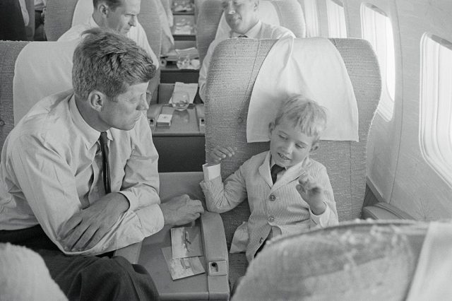 John Kennedy listens to his nephew Bobby Kennedy Jr. explain how the plane flies from Los Angeles to Boston as they return home from the Democratic National Convention. (Photo Credit: Bettmann / Contributor)