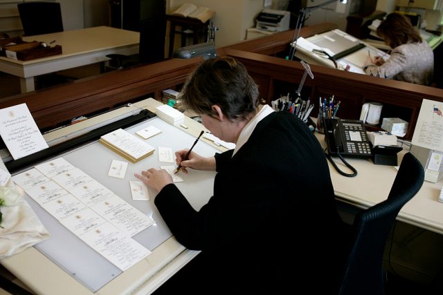 White House Calligraphers work on place cards and menus for the State Dinner in honor of Queen Elizabeth II. The White employees three full time calligraphers, who create awards, citations, invitations, place cards and numerous other hand written items. (Photo Credit: Brooks Kraft LLC/Corbis via Getty Images)